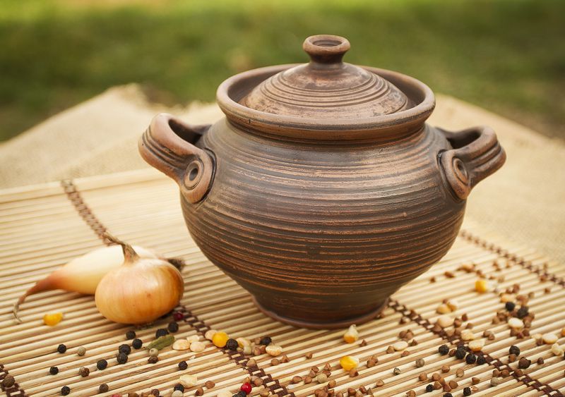 Brown big ceramic pot with lid made of red clay. 