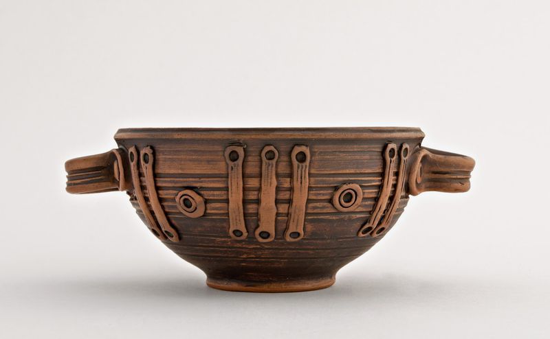 Ceramic bowl with handles made of red clay. 