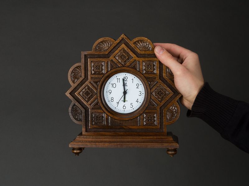 Wooden alarm clock with hand carved pattern.