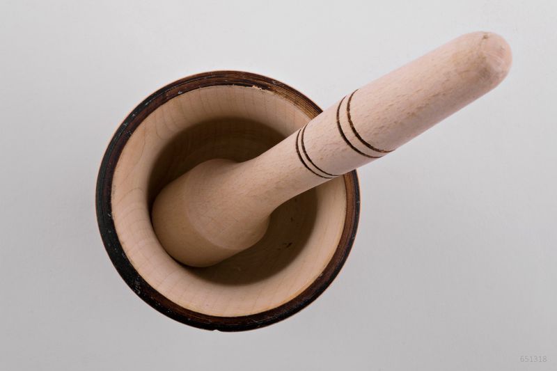 Wooden mortar and pestle for grinding spices by hand.